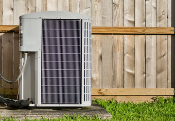 Central air conditioner condenser unit mounted outside a home