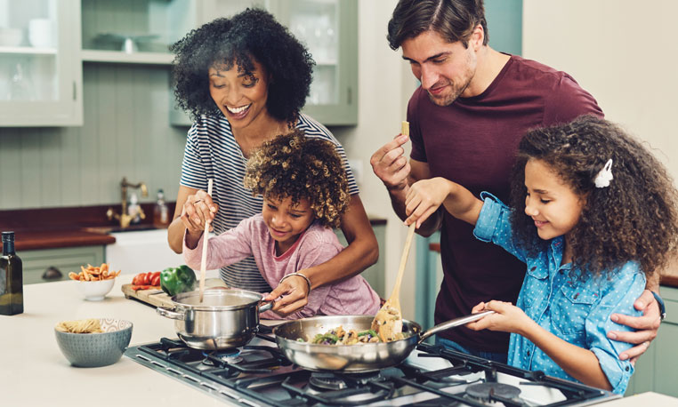 Happy family using ckSmithSuperior Propane to cook dinner