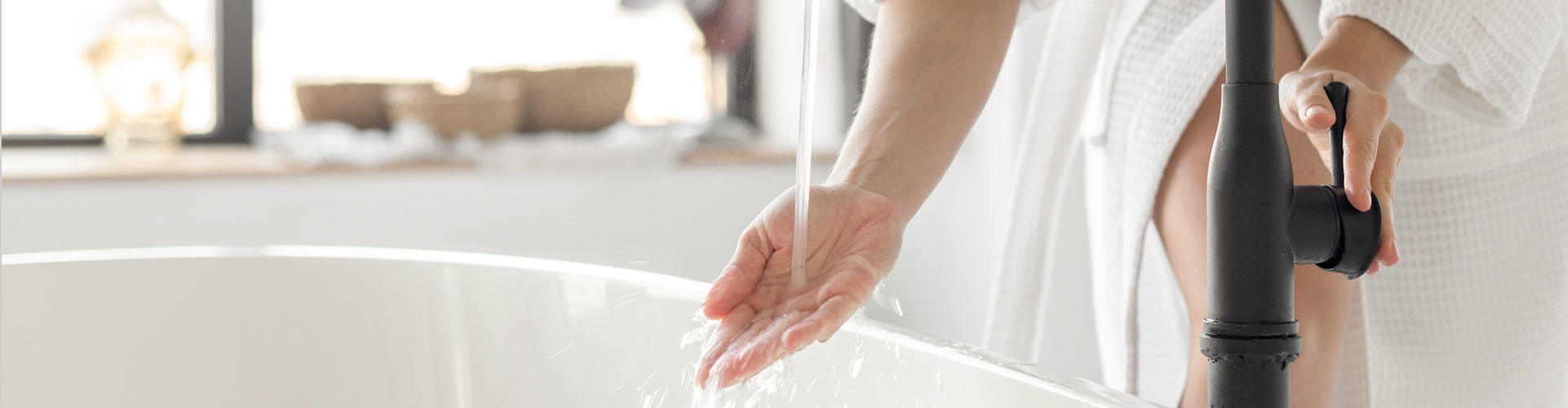 Woman drawing a bath with warm water supplied by a ckSmithSuperior installed hot water heater